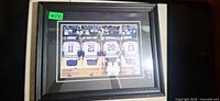 Front view of framed photograph showing jersey lineup and frame detail