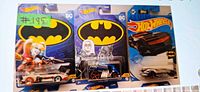 Three sealed Hot Wheels Batman vehicles: white/red, blue, black/orange