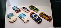 Group shot of seven Hot Wheels diecast cars showing colors, body styles and graphics