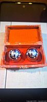 Open box showing two chrome sounding balls