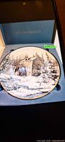 Plate in presentation box showing winter mill scene and artist signature