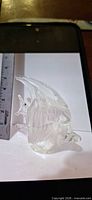 Side view of clear glass angelfish paperweight next to ruler for scale