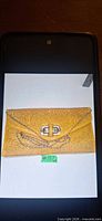 Yellow textured envelope clutch showing texture, clasp and chain strap