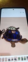 Front view of blue stained glass turtle lamp with baby turtle on shell