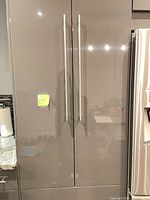 Tall glossy gray pantry cabinet with long stainless pulls