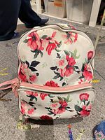 Front view of floral kensie mini backpack showing front zip pocket and overall condition