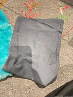 Gray fleece tube beanie beside teal faux-fur hat