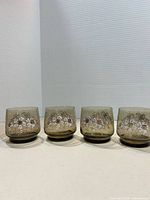 Front view of four matching amber glasses with floral design