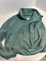 Front view showing color, half-zip, kangaroo pocket, collar, logo patch