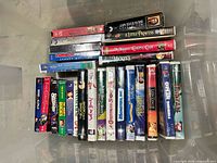 Partially filled plastic bin showing stacked VHS tapes, titles visible include Finding Nemo and Tarzan