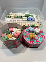 Assorted bubble candles in two decorative boxes and clear bin