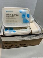 Box containing multiple Stephenson Melt & Pour Crystal soap base tubs, one tub placed on top for label visibility