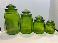 Front view of all four green octagonal canisters with lids
