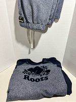 Sweatpants hanging showing cuff and waistband, sweatshirt folded below