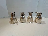 Front view of four silver-plated animal-head cups