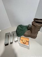 Boots, hat, metal letter M and coin pouch grouped together
