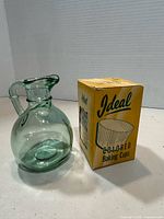 Box of Ideal colored baking cups beside green glass pitcher
