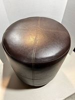 Top view showing dark brown leather surface and cross-stitching