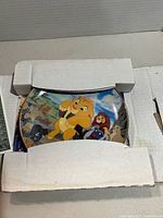 Plate partly removed from original cardboard holder showing Lion King artwork