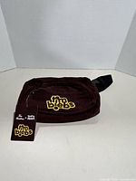 Front view of brown corduroy fanny pack showing Timbiebs logo and hang tag