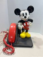 Front view of Mickey Mouse telephone with handset on base
