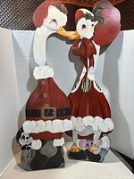 Front view of both hand-painted wooden goose figures dressed as Santa and Mrs. Claus