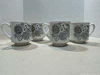 Front view of four mugs highlighting floral design
