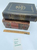 Two dictionaries stacked with ruler for scale