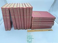 Front view of all 15 red gilt-stamped encyclopedia volumes upright and stacked