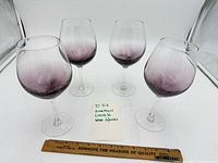 Four amethyst crackle wine glasses displayed with ruler for scale