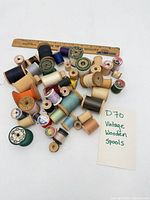 Group of vintage wooden spools with ruler for scale