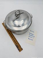 Top view of hammered aluminum covered carrier beside ruler