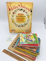 Front view showing The Golden Dictionary and stacked additional books