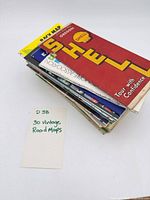 Stack of folded maps showing Shell cover and note card stating 30 vintage road maps