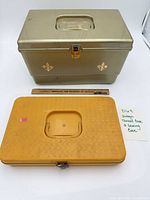 Gold and yellow plastic sewing cases with ruler for scale