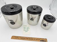 Set of three West Bend stainless canisters with ruler for scale