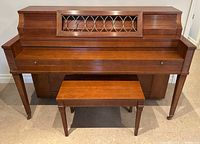 Front view of Heintzman upright grand piano with bench