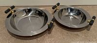 Top view of both stainless steel bowls showing size difference and handles