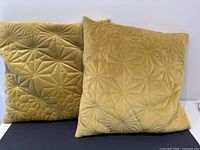 Two mustard velvet cushions, quilted fronts displayed