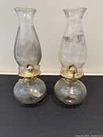 Both clear hobnail glass oil lamps side by side