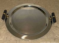Full view of stainless steel round tray showing handles and surface