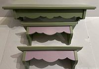 Three graduated painted wooden shelves front view