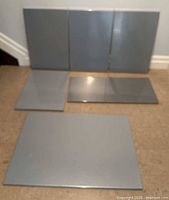Front view of all six gray metal boards, showing size variations