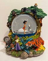 Front view showing snow globe with Baloo and Mowgli, exterior characters Shanti, Ranjan, Shere Khan, elephant calf