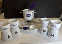 full set displayed, showing mugs, fondue pot, stand and tray