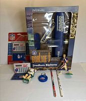 Full lot view showing boxed biplane, sealed calculator set, two figurines, keychain and pencils