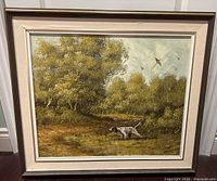 Full view of framed oil painting showing hunting dog scene