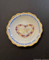 Front of bone china dish showing floral heart, ER monogram, blue commemorative text, gold rim