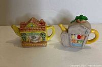 Front view of both Red Rose miniature teapots showing shapes and colours