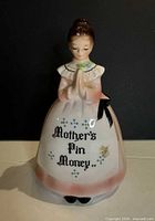 Front view of ceramic praying lady bank showing inscription and overall appearance